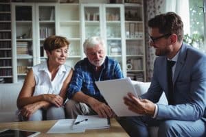 Later Life Finance equity Release mortgage Appointment with an older couple and their financial adviser discussing the mortgage figures