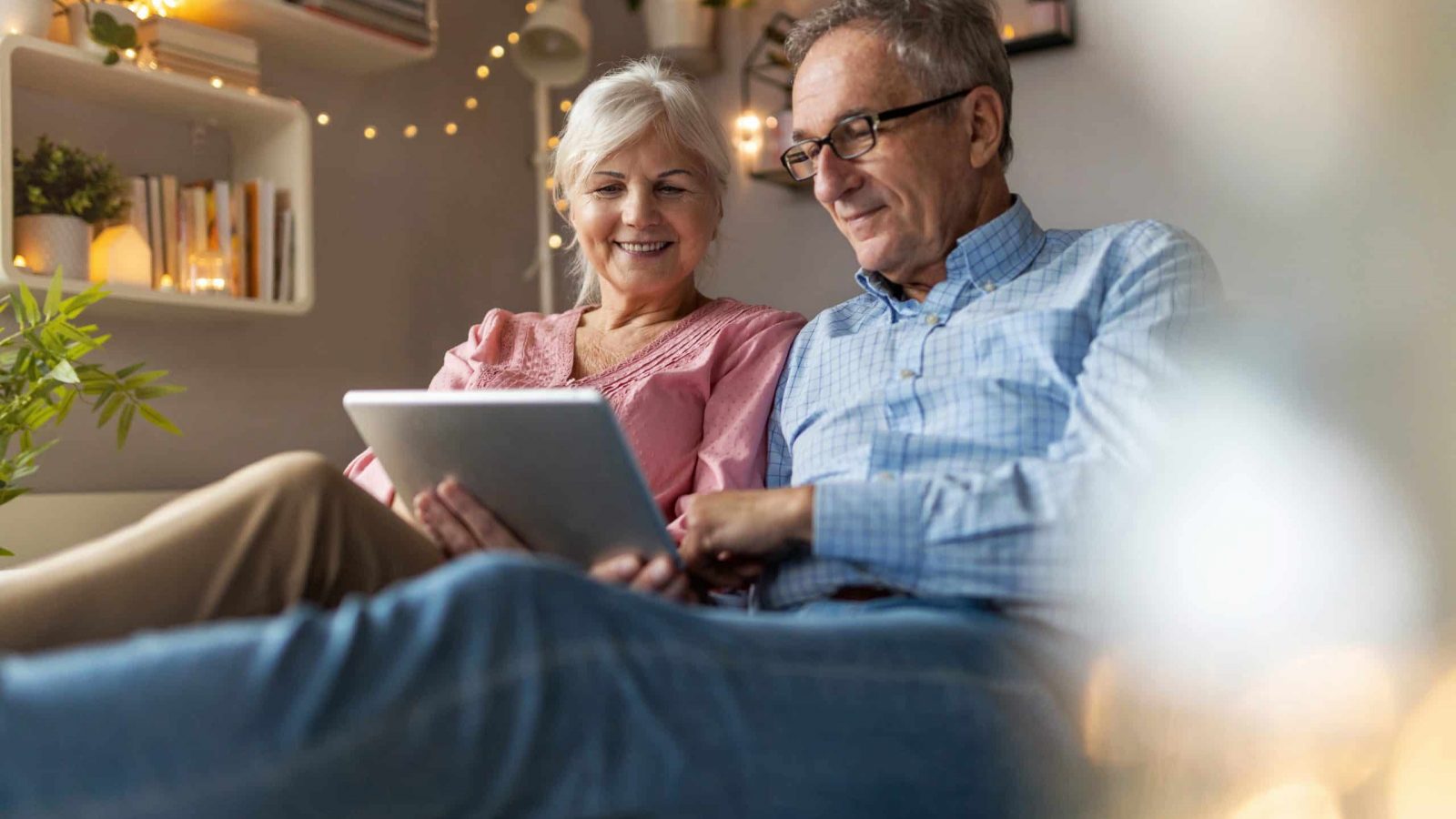 Mature couple using a laptop while relaxing at home Comparing the best Equity Release companies available on a laptop